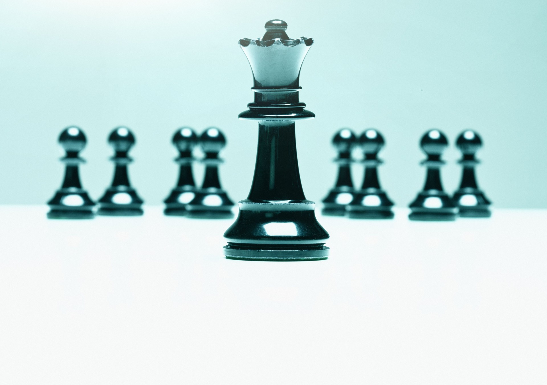 Chess queen leads a group of pawns, symbolizing female leadership, power and success